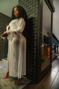 a woman in a white dress standing in a bathroom